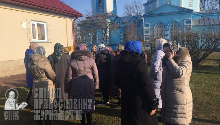 Прихожане наблюдают за вооруженными захватчиками с безопасного расстояния