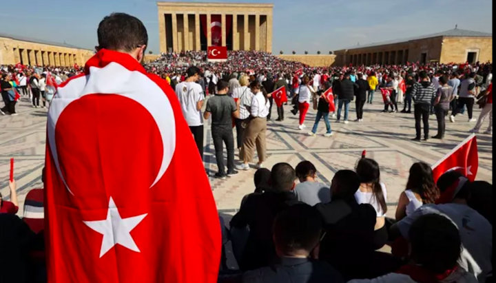 A man wrapped in the Turkish national flag stands near Anıtkabir, the mausoleum of Mustafa Kemal Atatürk, founder of the Turkish Republic. Photo: Adem Altan / AFP via Getty Images